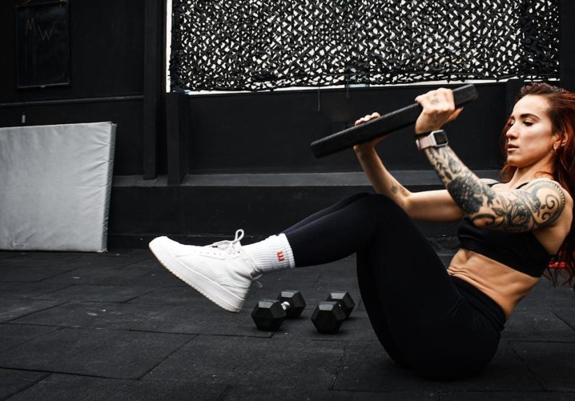 A determined woman performs a core workout in an indoor gym setting.